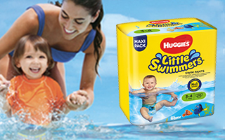 Mamma e figlio che giocano e ridono in acqua con Huggies® Little Swimmers